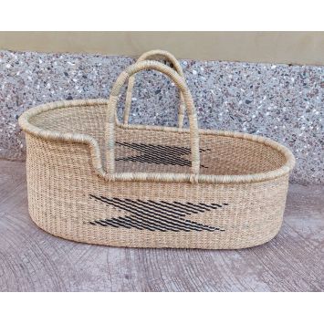 A handwoven tan baby Moses basket or bassinet with a black geometric pattern