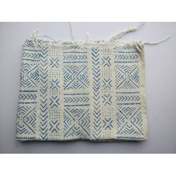 Folded white with blue patterns mudcloth on the floor.