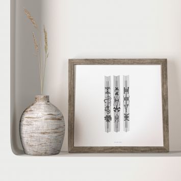 A black and white painting on a white background, framed and placed next to a vase