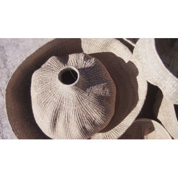 Top view of a tan Ilala garlic gourd inside a woven basket