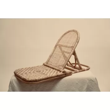 Side view of a tan Foldup Rattan beach chair on a white surface