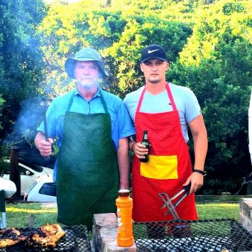 Two men in a green and a red Shweshwe apron