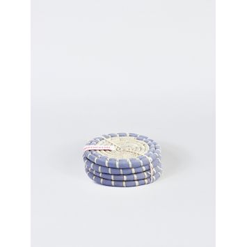 Four gray and natural tan round grass woven coasters stacked on top of each other bound together with a natural tan string