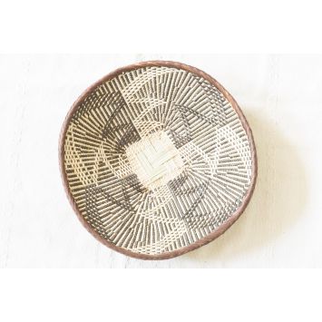 A top view of a binga basket with brown edging and an intricate black and beige pattern. The centre is a square and in a plain beige
