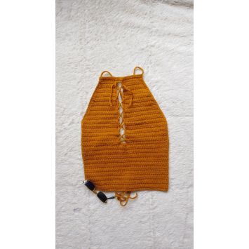 Flatlay of an orange crochet halter top with sunglasses next to it