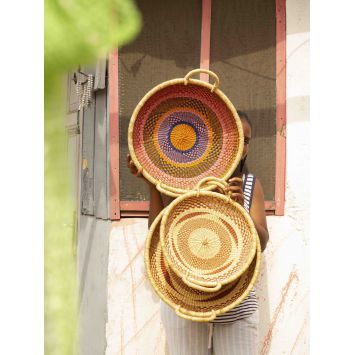 Front view of model holding three assorted Koleke baskets showing inside